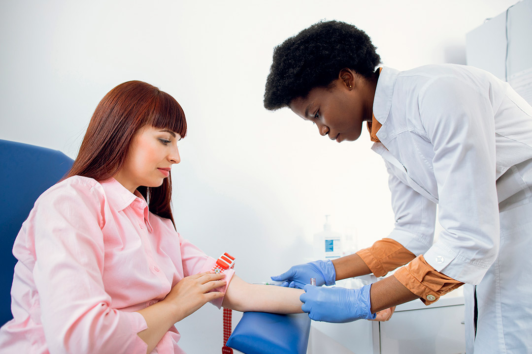 mujer profesional sanitaria haciendo un análisis de sangre a un paciente.  